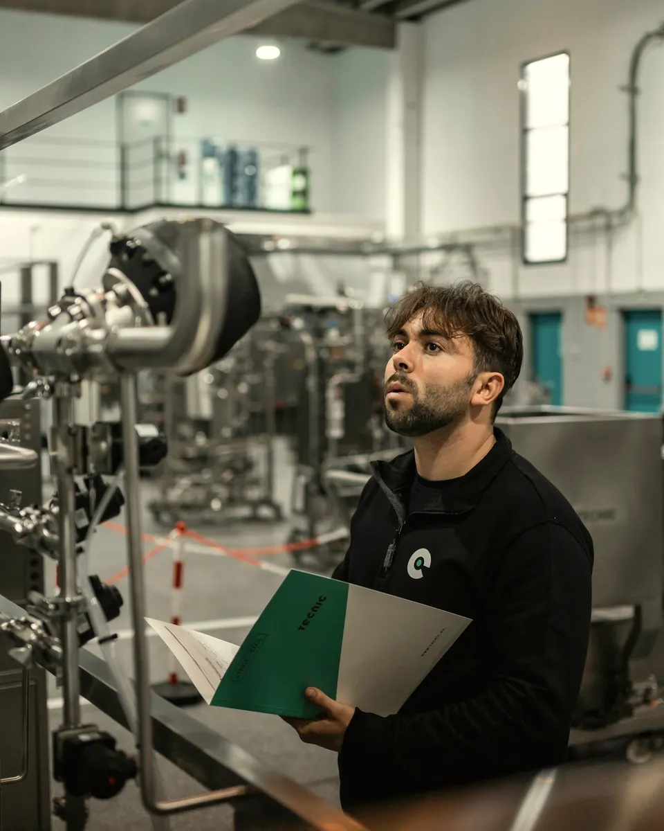A technician checks process equipment in a clean plant.