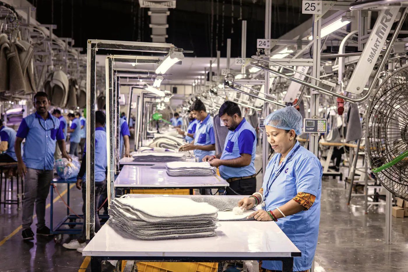 Workers at stations along a factory floor.